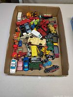 Overview of box filled with assorted die-cast vehicles