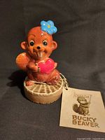 Front view of ceramic Bucky Beaver figurine on stump base with tag