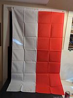 Full view of flag hanging showing white and red sections