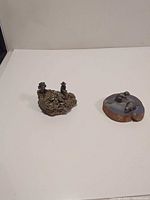 Both pewter figurine displays on white surface