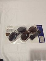 Front of sealed package showing three pairs of sunglasses