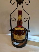 Full view of wrought iron stand and bottle