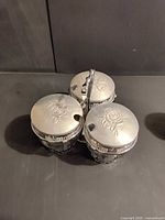 top view of three jar lids showing floral embossing