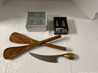 Overall lot view with spoons, cheese knife, boxed candle holders, boxed Stelton shakers