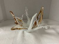 Angled view of star-shaped Murano glass bowl showing clear, white and amber coloration