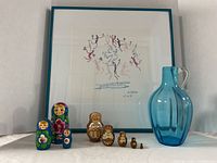 Print, nesting dolls and blue glass vase grouped for full lot view