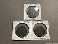 Obverse sides of all three tokens in holders