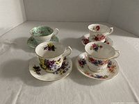 Four Paragon floral tea cups with matching saucers displayed