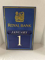 Front of blue metal Royal Bank perpetual calendar showing January 1 card inserted