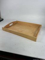 Top view of rectangular wooden tray showing handles and raised edge