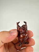 Front view of wooden Hotei figure held in hand