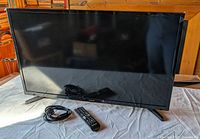 Front view of Samsung LED TV with remote and power cord