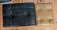 Black and beige footrests top view showing tufted tops and wear