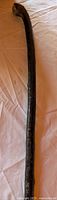 Full length view of black wooden walking stick