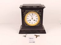 Front view of slate and marble mantel clock with keys