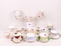 Full lot overview showing assorted teacups and saucers arranged on risers