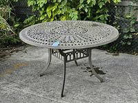 full view of round cast aluminum table on patio