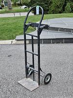Full view of hand truck dolly standing upright on driveway