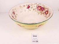 Full view of ceramic basin bowl showing interior floral pattern and exterior yellow band