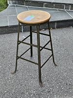 Full view of stool showing wood seat and metal frame