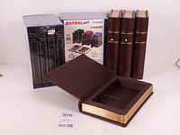 Group shot of four sealed Astral Photo albums, four brown faux-leather book-form items including open storage box