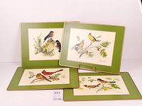 Four of the placemats showing bird illustrations and green borders
