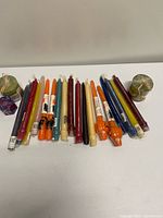 Group of assorted taper and pillar candles laid out on table