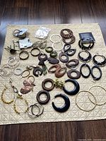 Top view of entire assortment displaying variety of hoop, dangle and drop earrings in different materials and finishes