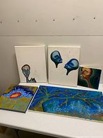 All five paintings grouped on table