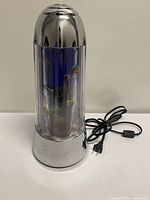 Full view of chrome-finish motion lamp with cord and inline switch