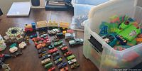 Wide view of diecast cars, track bin, train, playset pieces