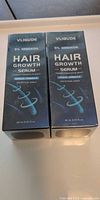 Front view of two Vligude 5 % Minoxidil Hair Growth Serum boxes
