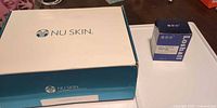 Closed NU SKIN ageLOC Body Spa kit box alongside unopened Loshall Cell Repair Factor box