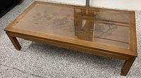 Full view of coffee table showing glass top and wood frame