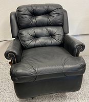 Front view of black leather Bradington-Young recliner showing tufted cushions and nailhead arms