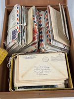 Bundled letters and envelopes filling wood box interior