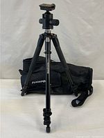 Tripod extended with ball head attached and carrying case behind