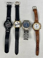 Front view of all four wristwatches laid flat