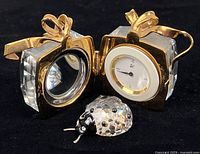 Ladybug figurine and open hinged crystal cube showing clock and mirror