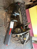 Chainsaw and trimmer together on workshop floor