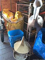 Metal crane, soil bag, blue bin with rocks