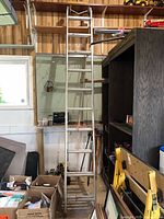 Full view of aluminum extension ladder leaning against wall