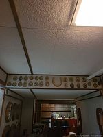 Row of brass horse brasses and central horseshoe mounted over doorway