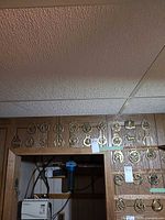 Multiple brass horse brasses mounted on wood panel above doorway