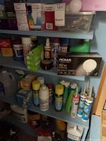 Shelves with mixed household supplies including light bulbs, sprays, sealants, solvents