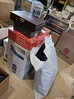 Full body massage mat box, Winchester wood box, bag containing massage pad visible among other boxes