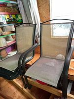 Two of the sling mesh chairs on shelf showing frame and seat material