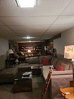 Basement view of grey microfiber sectional sofa with ottoman and pillows
