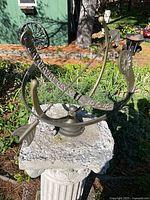 Overall view of metal armillary sundial on stone top