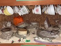 View of hanging teacups and wrapped saucers/plates